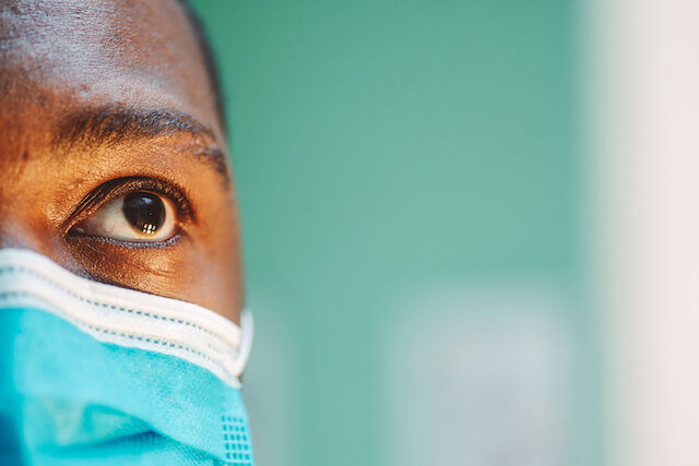 african american man in blue and white surgical face mask